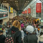 Público circula pelo Javits Center durante a New York Comic Con, com fãs usando fantasias de cosplay.