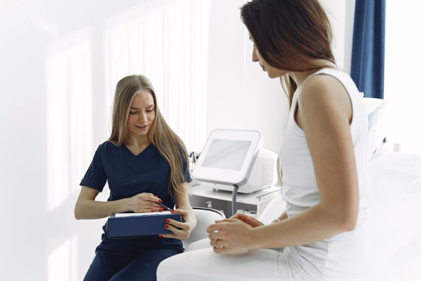 Profissional de saúde auxilia uma paciente durante uma consulta em uma clínica moderna e iluminada.